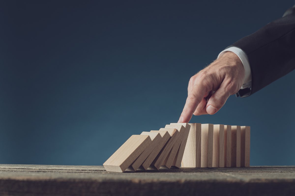 Un uomo butta giù un serie di domino