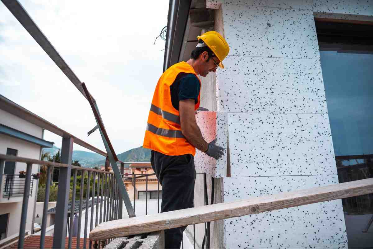 Operaio al lavoro nella copertura delle pareti esterne